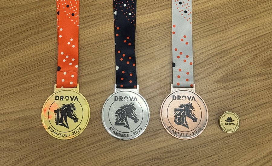 Close-up of the gold, silver and bronze Drova Stampede medals showing the horse silhouette mark and numbers one, two and three