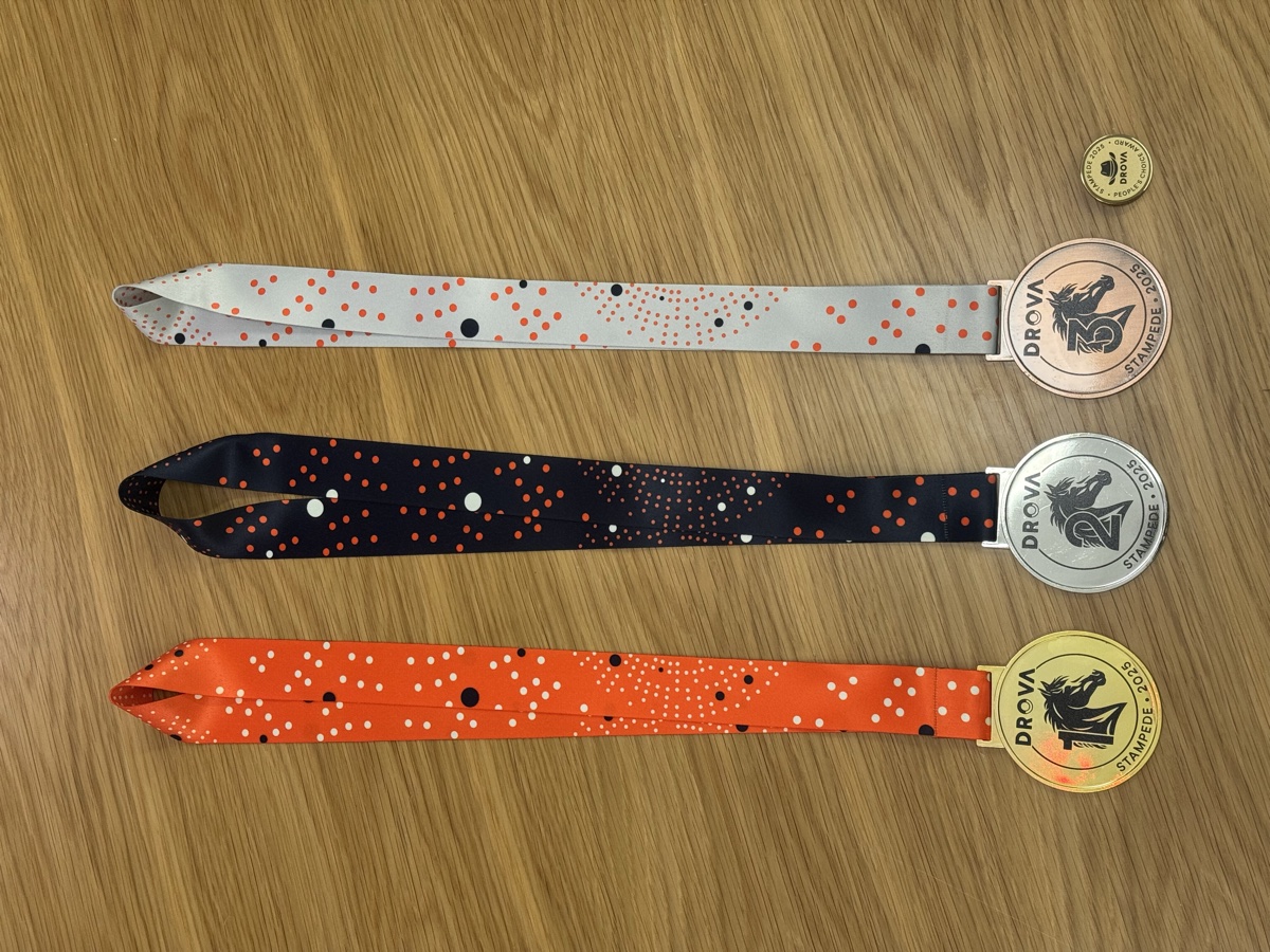 Three Drova Stampede medals with orange, navy and white dotted ribbons for first, second and third place