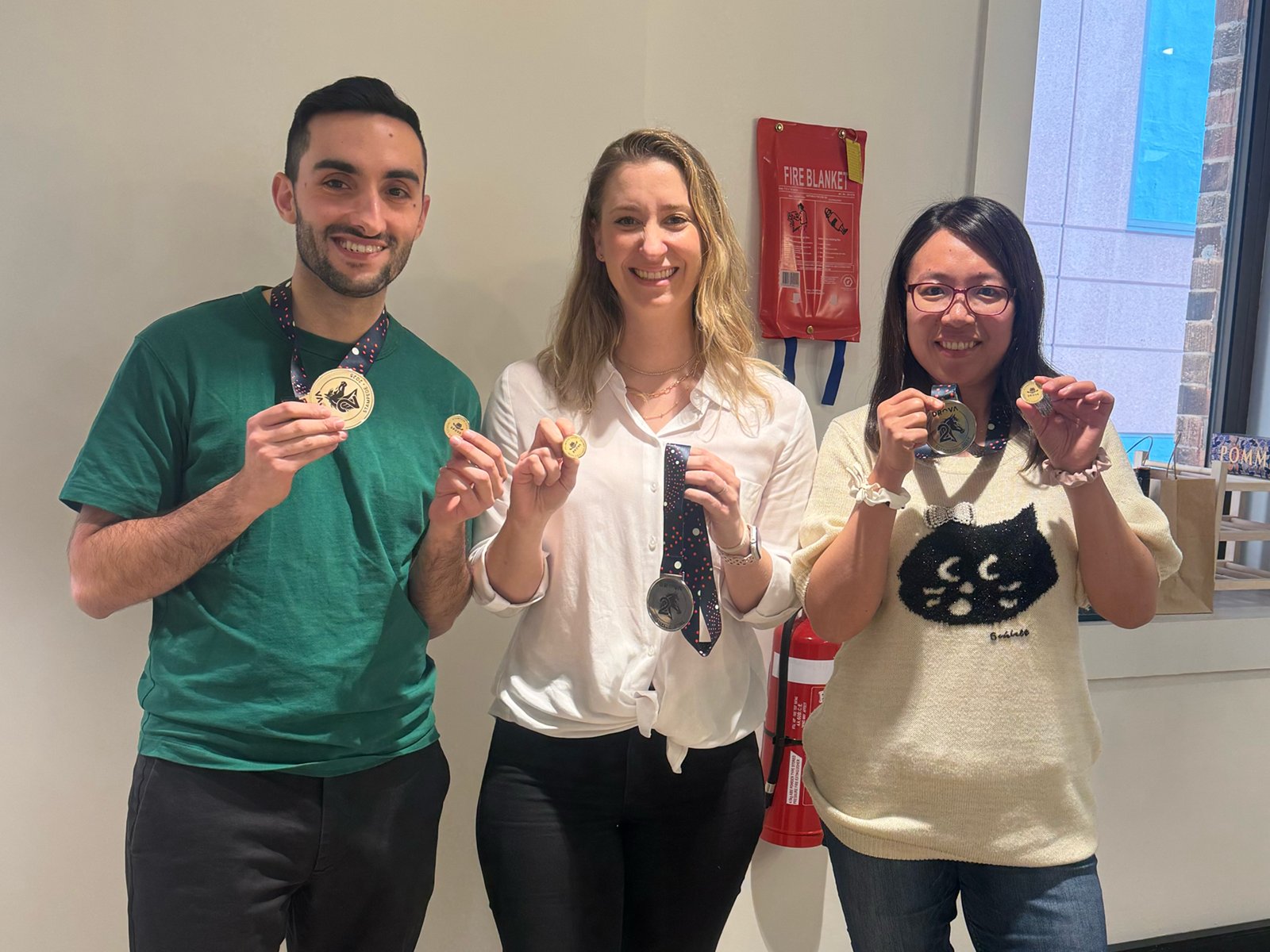 Three Drova colleagues in the Sydney office smiling and holding up their Stampede 2025 medals